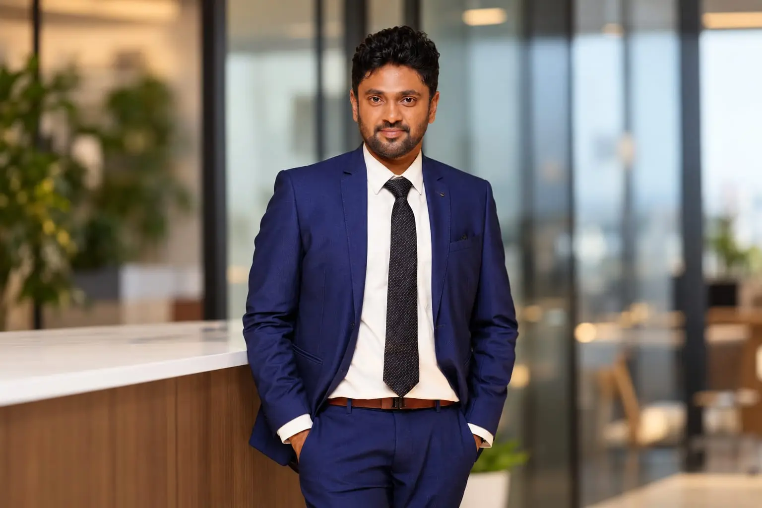 Sakthi Vignesh, Founder and CEO of Hazeberg Consulting, in a navy suit in the office