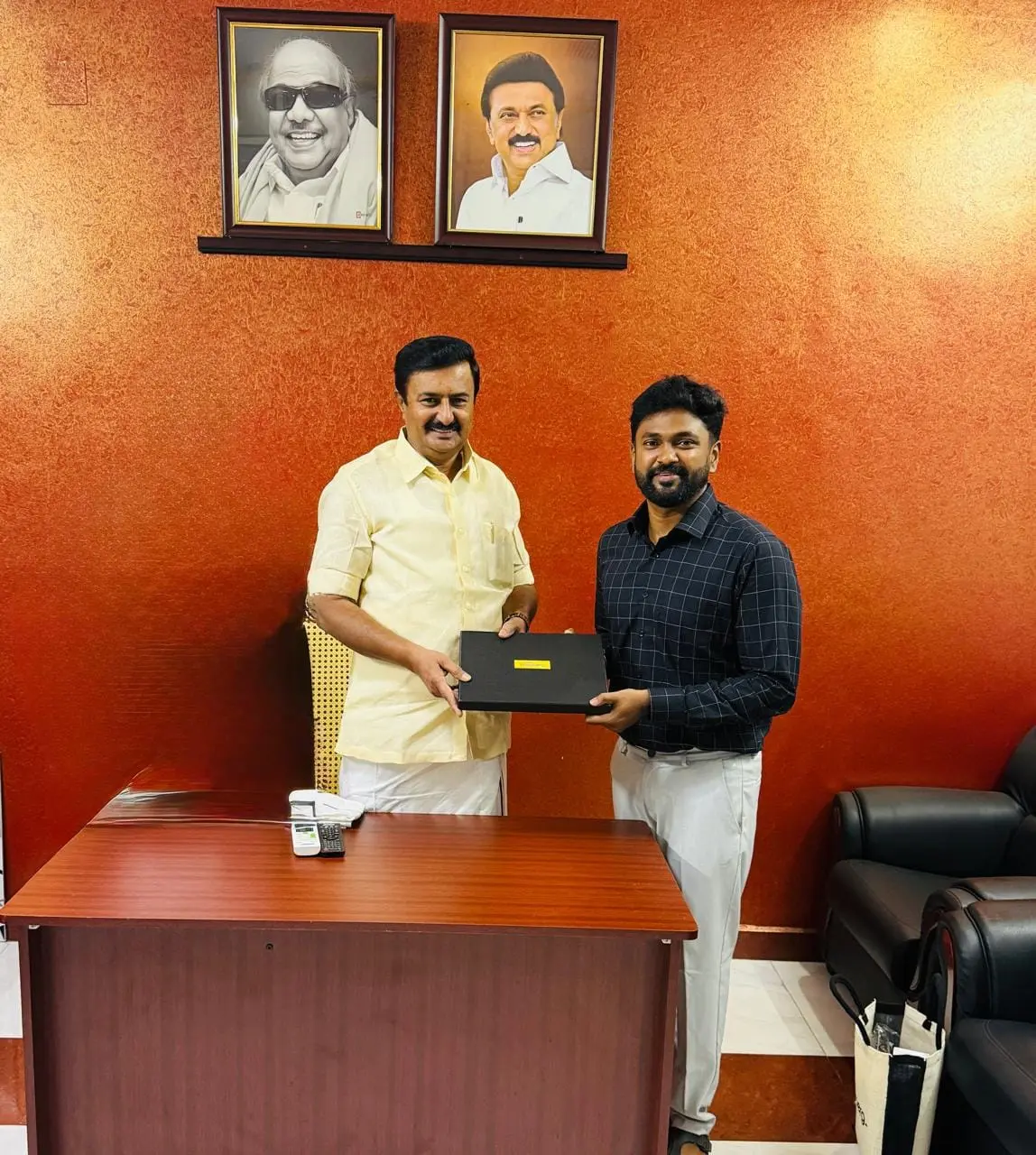 Sakthi Vignesh being presented with an award in an office