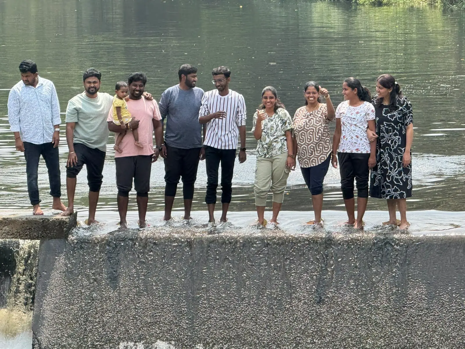 The team lined up along a riverside wall at the 2025 offsite