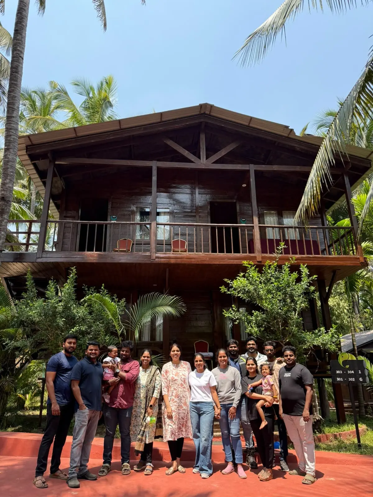 The team gathered in front of a wooden resort house at the 2025 offsite
