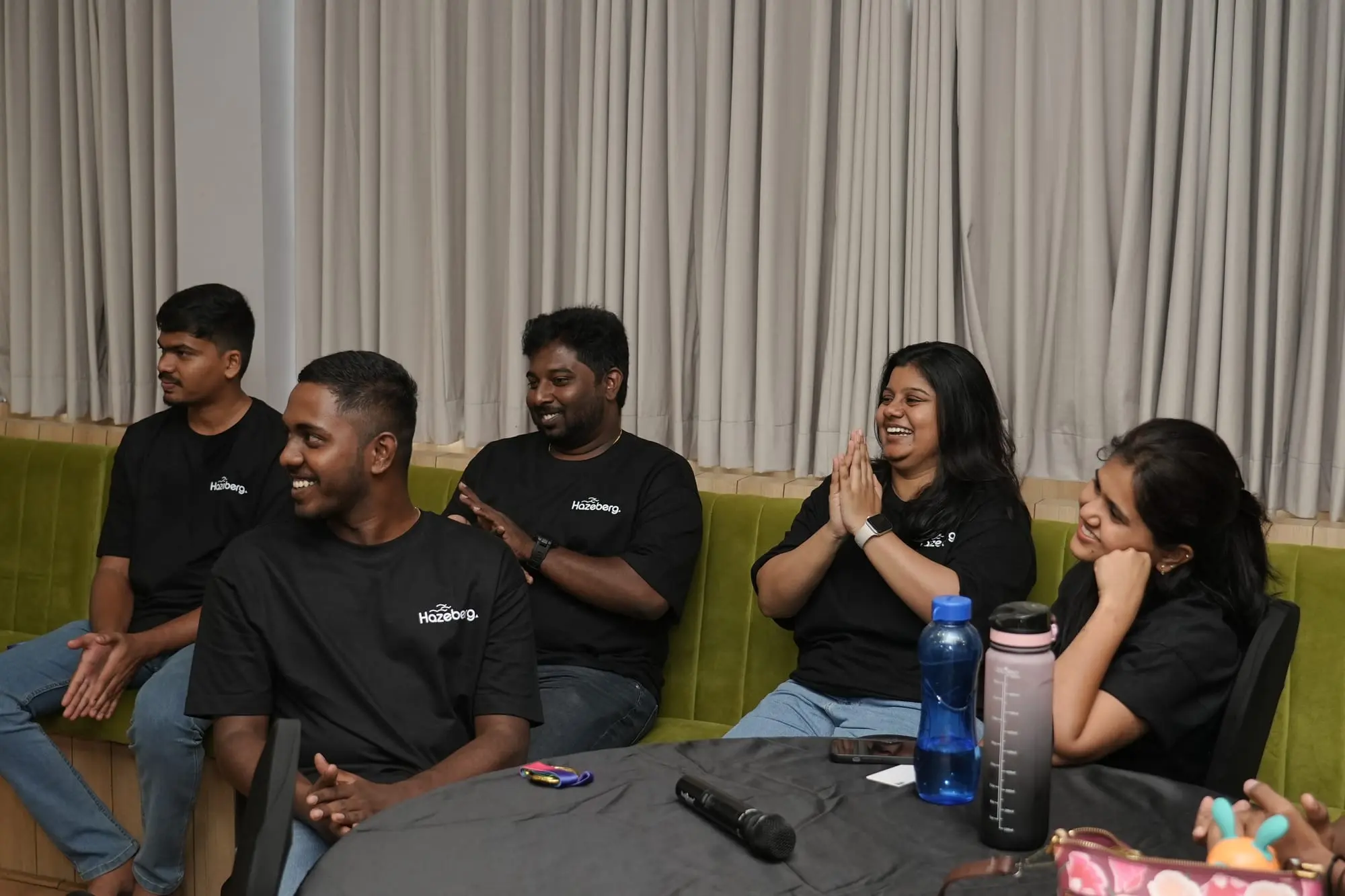 Team members seated together, laughing during a session at the 2026 offsite