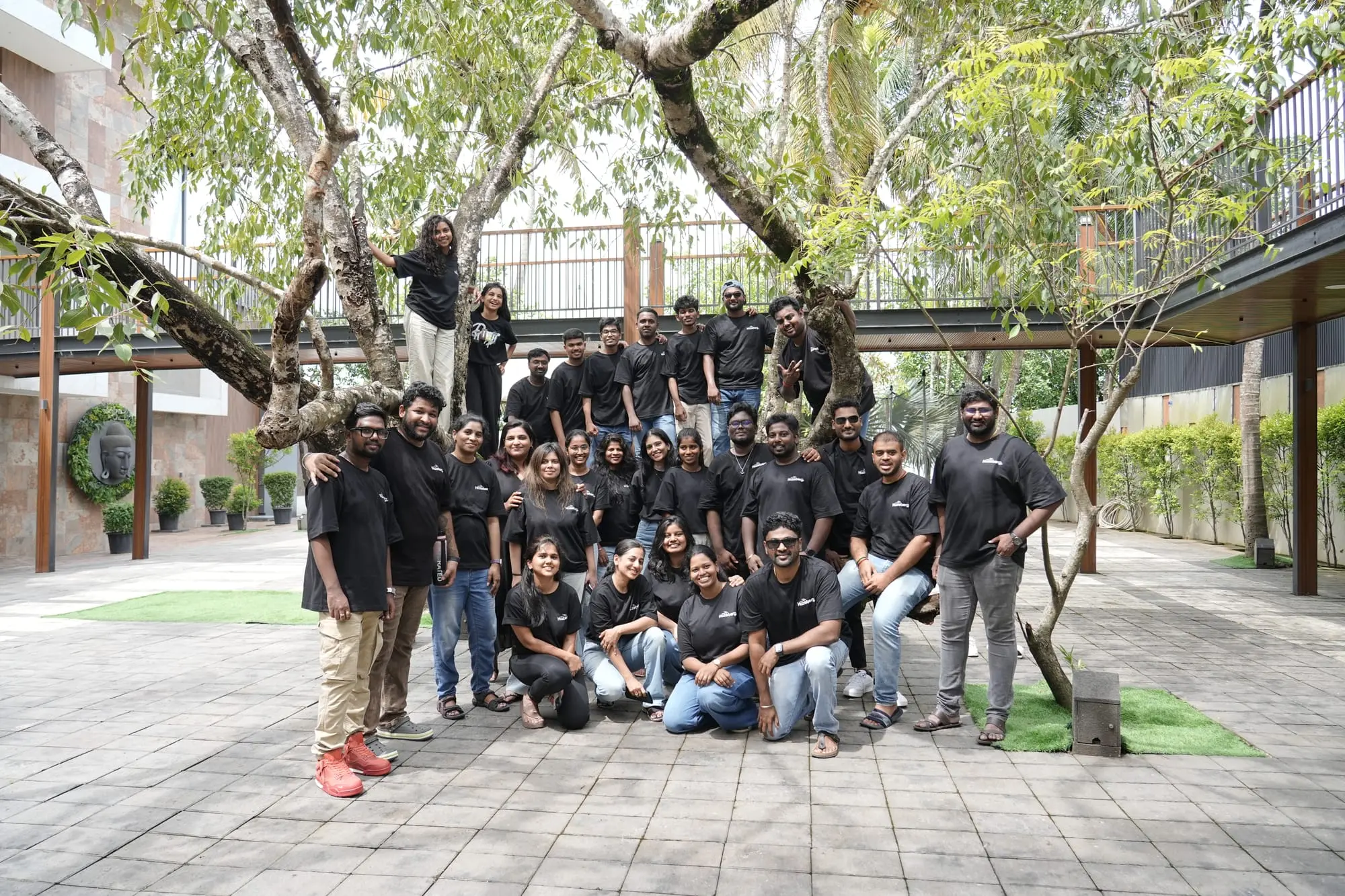 The whole team gathered outdoors under the trees at the 2026 offsite