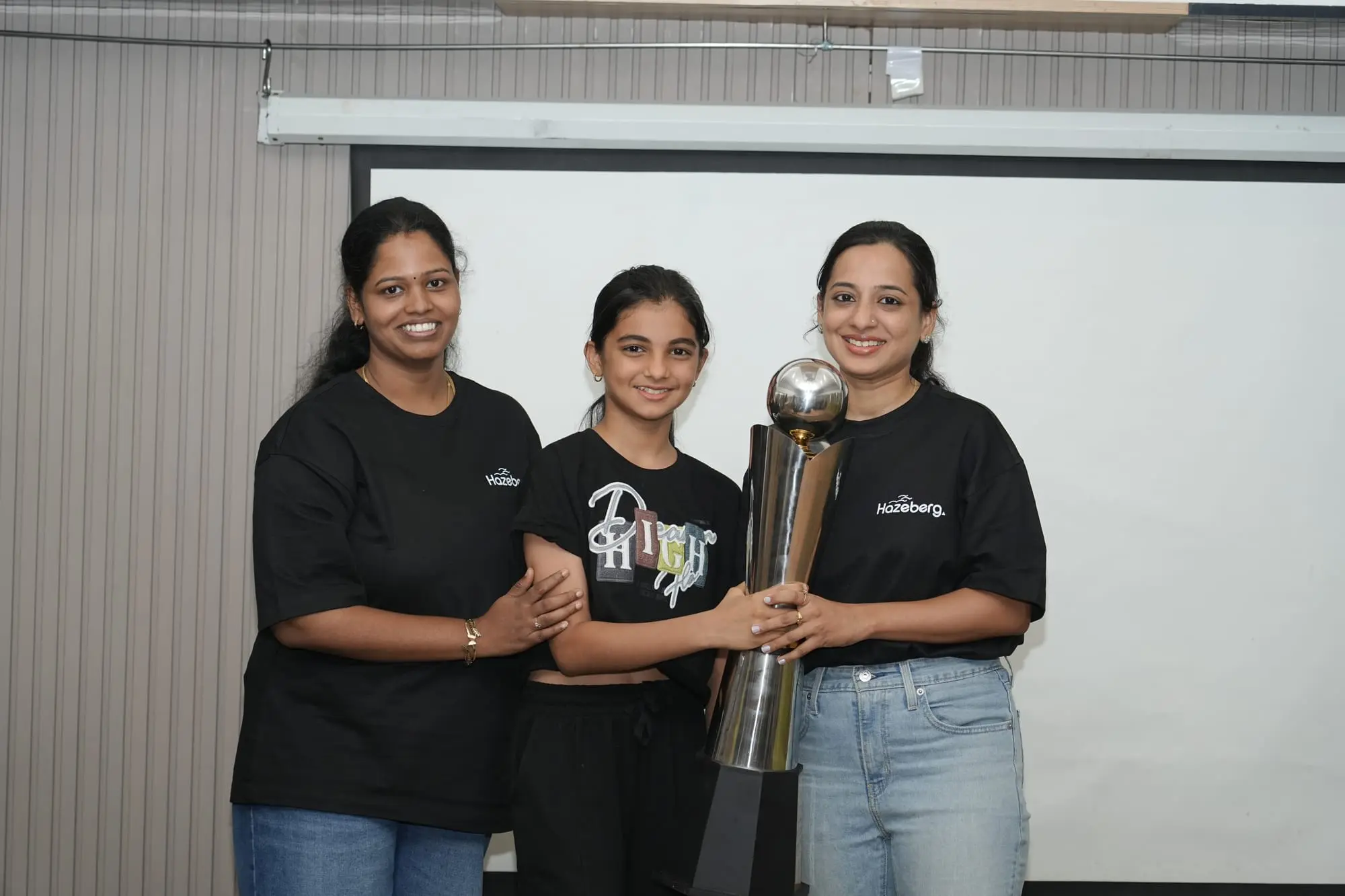 Namitha holding up her trophy with colleagues